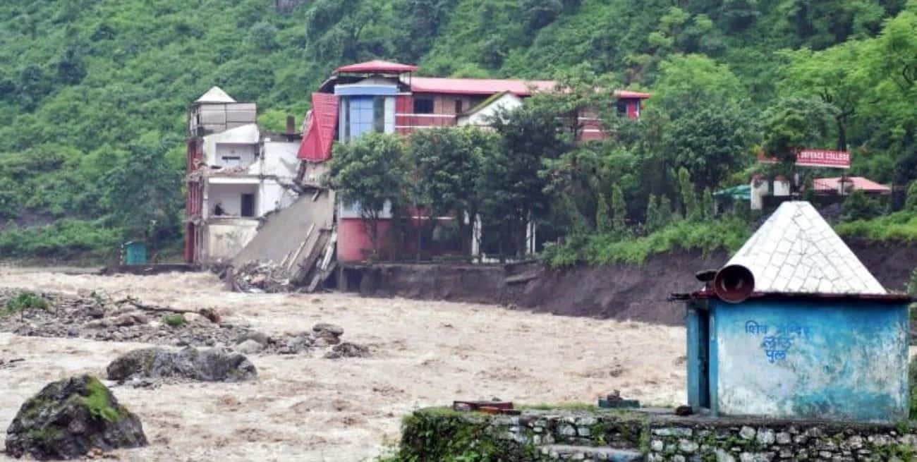 Un centro educativo parcialmente derrumbado sobre el río Maldevta a su paso por Dehradun, en India, como consecuencia de las fuertes lluvias, el 14 de agosto de 2023.