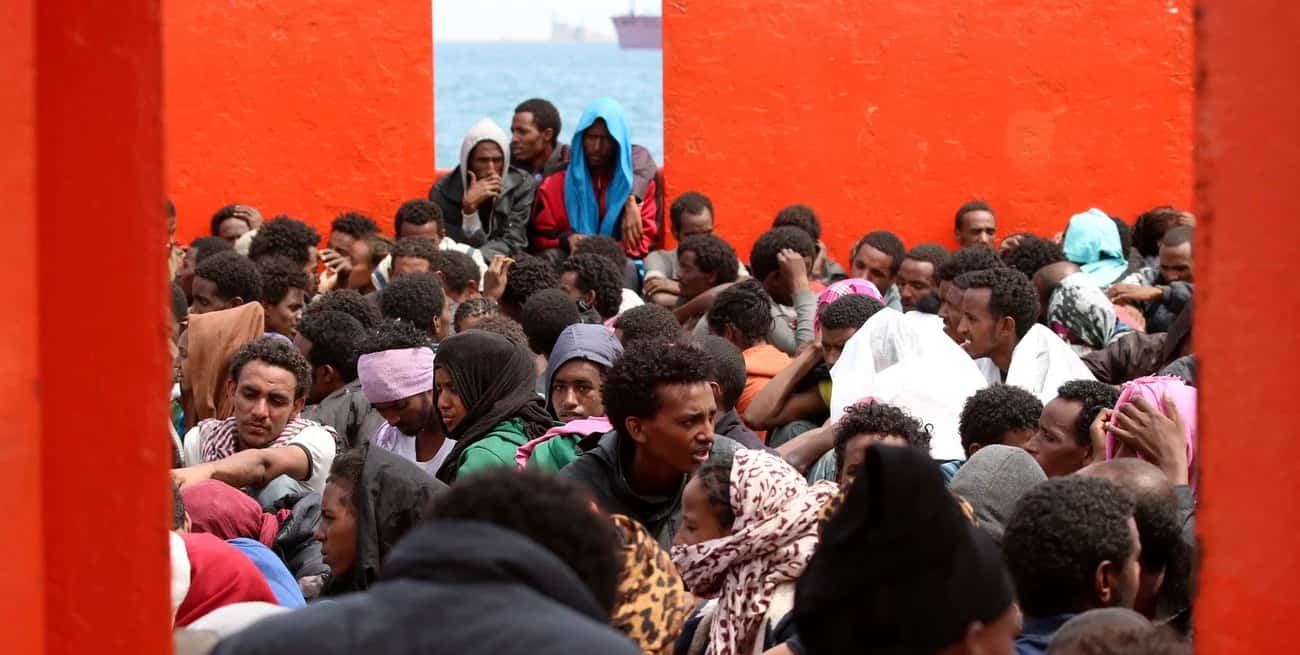 Los migrantes esperan a bordo de un barco de la marina antes de ser desembarcados en el puerto italiano. Crédito: REUTERS.