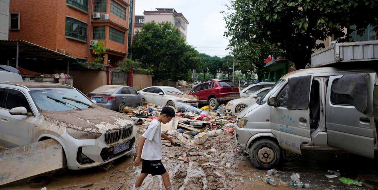 Un niño camina por una calle embarrada después de que fuertes lluvias inundaran la Guangdong, China. Crédito: REUTERS.