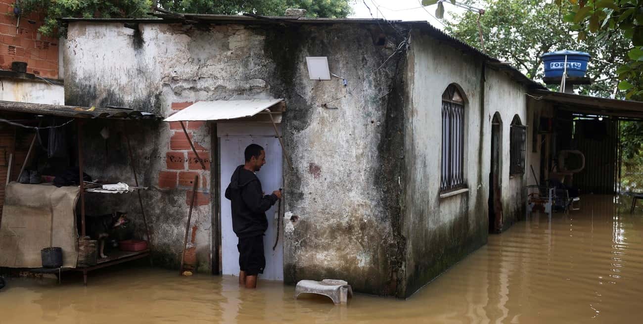 El trabajador de la construcción Nicelio Goncalves, de 52 años, abre la puerta de su casa inundada después de fuertes lluvias. Créditos: Reuters