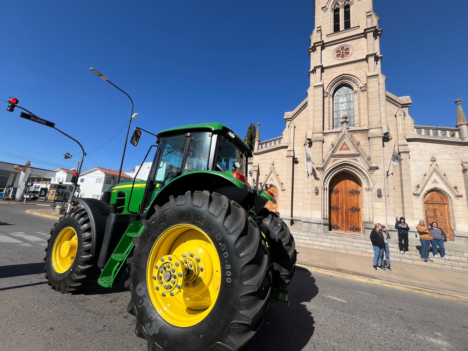 Inusual imagen de un potente tractor circulando por calle 25 de Mayo, frente a la Iglesia Catedral